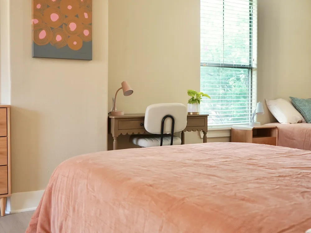 A private bedroom with a desk by the window at Empowered Treatment's transitional housing in Austin