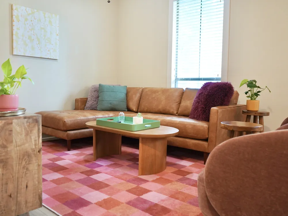 A common living area in Empowered Treatment's transitional housing with soft seating and natural light