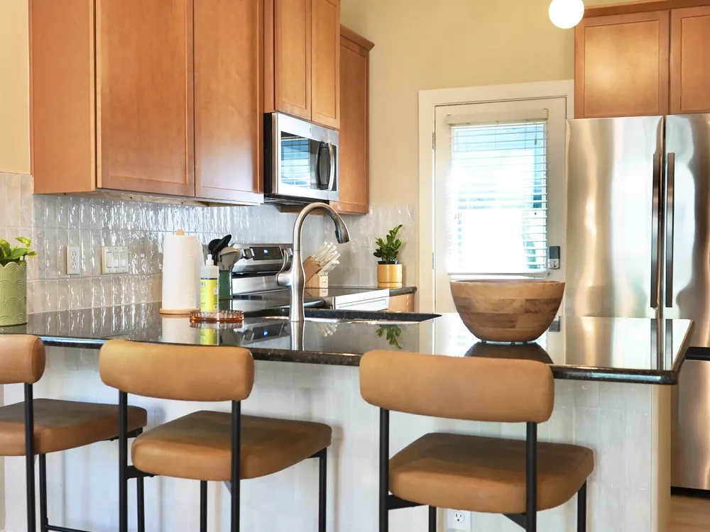 The kitchen in Empowered Treatment's transitional housing, with a breakfast bar, stools, and full-size appliances