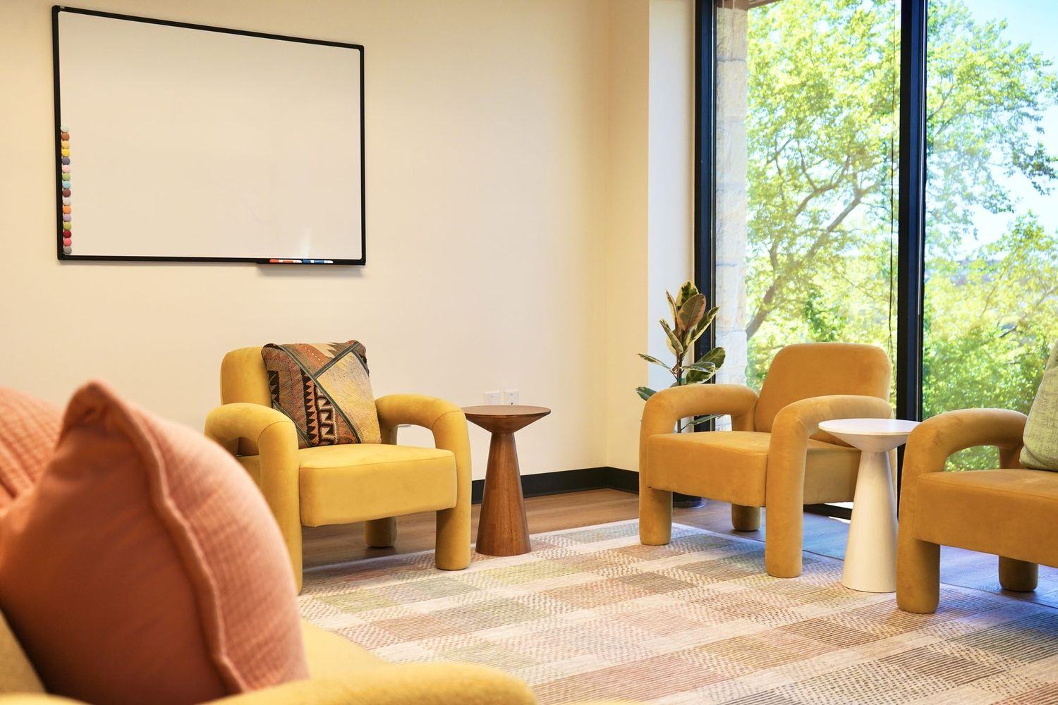 A group room at Empowered Treatment in Austin, with armchairs arranged in a circle beneath tall windows