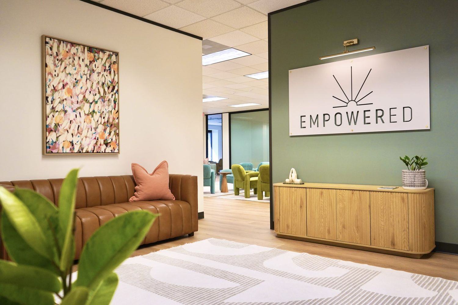 Reception at Empowered Treatment in Northwest Austin, with the Empowered wordmark on a deep green wall
