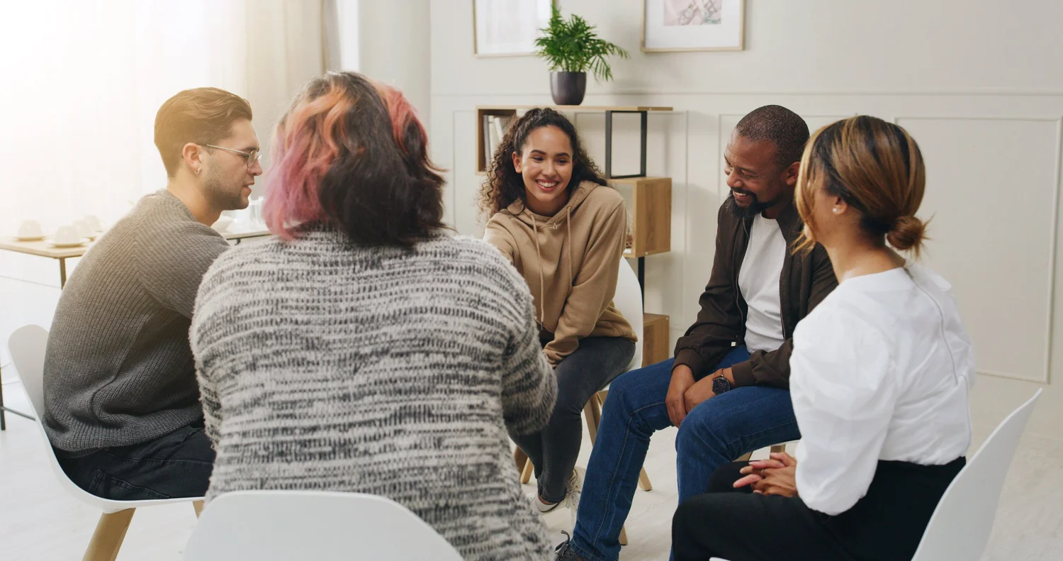 A group of people sitting in a bright indoor setting.