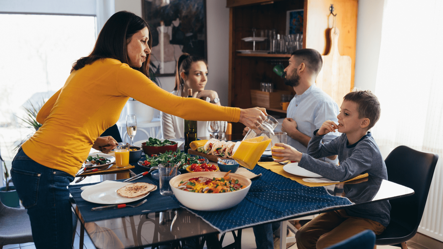 A family sitting around a table at mealtime.
