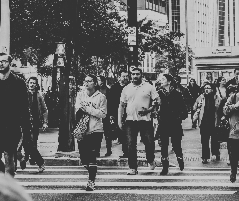 A diverse group of people walking outside on a public street.