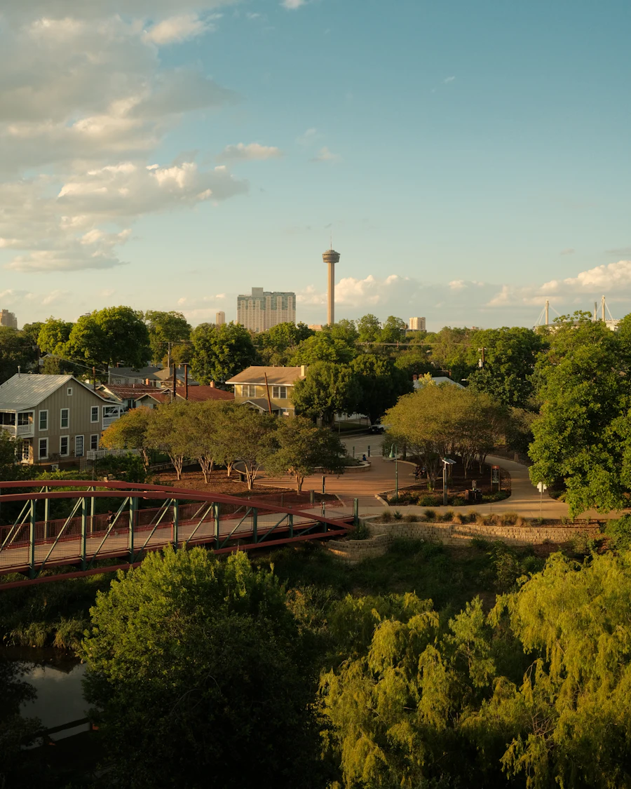 A park and footbridge with the Tower of the Americas in San Antonio